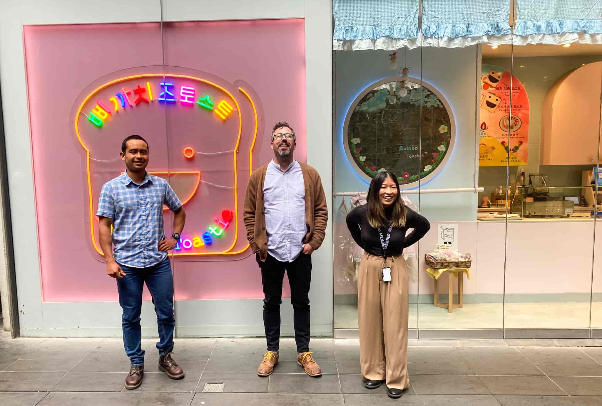 Emmanuel Cordoba, Ian Hammond and Lisa Lowe standing out the front of a fluro multicoloured neon toast